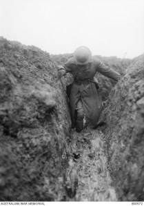 Description: Informal portrait of Captain C E W Bean, Official War Correspondent, knee deep in mud in Gird trench, near Gueudecourt in France, during the winter of 1916-1917